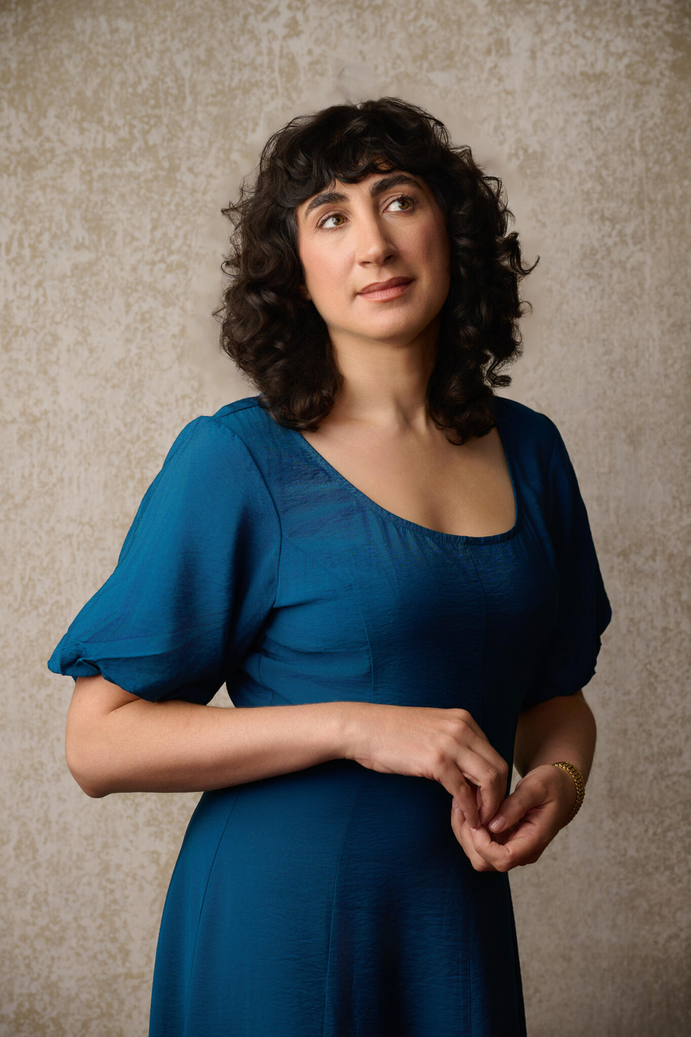 Rose Ciesla standing contemplatively in a blue dress